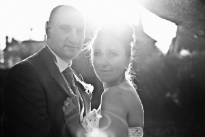 Black and white picture of bride and groom with sun shining behind them - Picture by Daniel Hough Photography